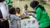 Un travailleur enseigne à plusieurs enfants comment se laver correctement les mains à l'entrée de l'hôpital Mbagathi de Nairobi, au Kenya, le 18 mars 2020. (Photo: LUIS TATO / AFP)