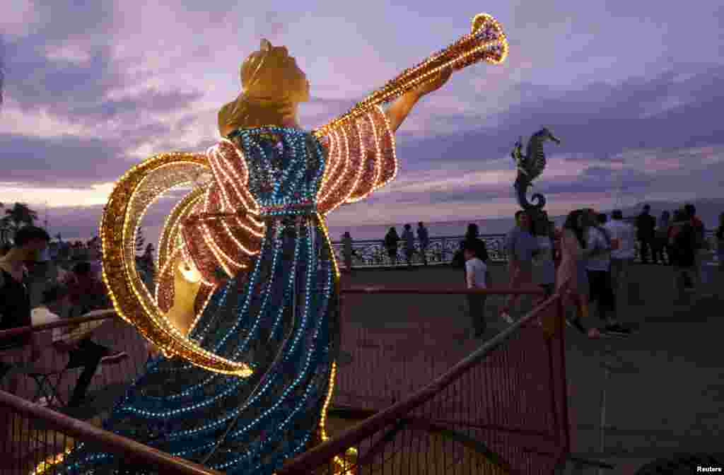People walk past Christmas decorations along the city's historic boardwalk in the Pacific beach resort of Puerto Vallarta, Mexico, Dec. 29, 2015.