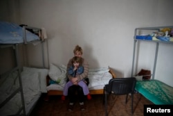 FILE - Refugees, who left their homes because of the fighting in eastern Ukraine, are seen in a volunteer centre in Slaviansk, March 12, 2015.