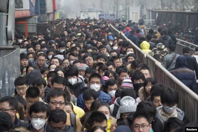 2015年12月8日，在北京首次发布空气污染红色警报后，乘客在地铁站排队