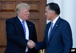 FILE - President-elect Donald Trump and Mitt Romney shake hands as Romney leaves Trump National Golf Club Bedminster in Bedminster, N.J., Nov. 19, 2016.