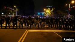 Police in riot gear block a roadway to stop demonstrators from entering a neighborhood as they protest the police shooting of Keith Scott in Charlotte, North Carolina, U.S., September 25, 2016.