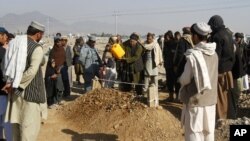 Seorang warga Afghanistan menuangkan air ke makam seorang korban korban akibat bentrokan pejuang Taliban dan pasukan Afghanistan di Bandara Kandahar, Afghanistan (10/12). 