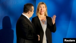 Serbian Foreign Minister Ivica Dacic greets European Union foreign policy chief Federica Mogherini as she arrives for an OSCE Ministerial Council meeting in Belgrade, Serbia, Dec. 3, 2015. 