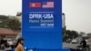 A motorist rides past a sign for the upcoming summit between U.S. President Donald Trump and North Korean leader Kim Jong Un, along a busy road in Hanoi, Feb. 19, 2019. 