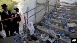 Ultra Orthodox Jews look at the scene where fatalities were reported among the thousands of ultra-Orthodox Jews during Lag BaOmer festival at Mt. Meron in northern Israel, Friday, April 30, 2021. (AP Photo/Sebastian Scheiner)