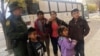 Archivo - Una familia de migrantes centroamericanos aguarda frente a un refugio en El Paso, Texas, el 29 de noviembre de 2018.
