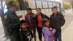 Archivo - Una familia de migrantes centroamericanos aguarda frente a un refugio en El Paso, Texas, el 29 de noviembre de 2018.