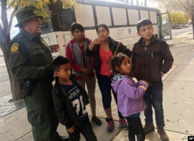 Archivo - Una familia de migrantes de Centro América espera frente a un refugio en El Paso, Texas, el 29 de noviembre, de 2018.