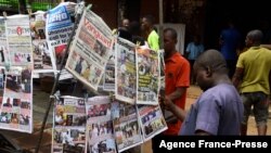 Bystanders read newspapers on a stall in Onitsha, Anambra State, southeastern Nigeria, on Nov. 5, 2021.