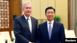 China's Vice President Li Yuanchao and U.S. Deputy Secretary of State William Burns (L) pose for a photo as they shake hands during a meeting at the Great Hall of the People in Beijing, Jan. 22, 2014.