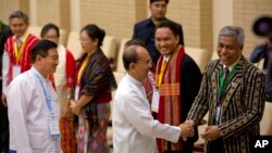 Presiden Myanmar Thein Sein, ketiga kanan, tersenyum sambil berjabat tangan dengan perwakilan kelompok pemberontak etnis dalam pertemuan Kesepakatan Gencatan Senjata (NCA) antara perwakilan pemerintah Myanmar dan pemimpin kelompok pemberontak etnis di Naypyidaw, Myanmar, Rabu, 9 September 2015. (AP Photo/Gemunu Amarasinghe)