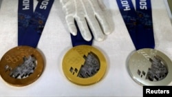 An employee arranges medals for the 2014 Winter Olympic Games during a presentation for the public at a jewellery shop in St. Petersburg September 19, 2013.