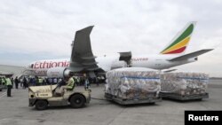 Le personnel d'Ethiopian Airlines transporte un lot de dons médicaux en provenance de Chine à l'aéroport international de Bole à Addis-Abeba, en Ethiopie, le 22 mars 2020. REUTERS/Tiksa Negeri 