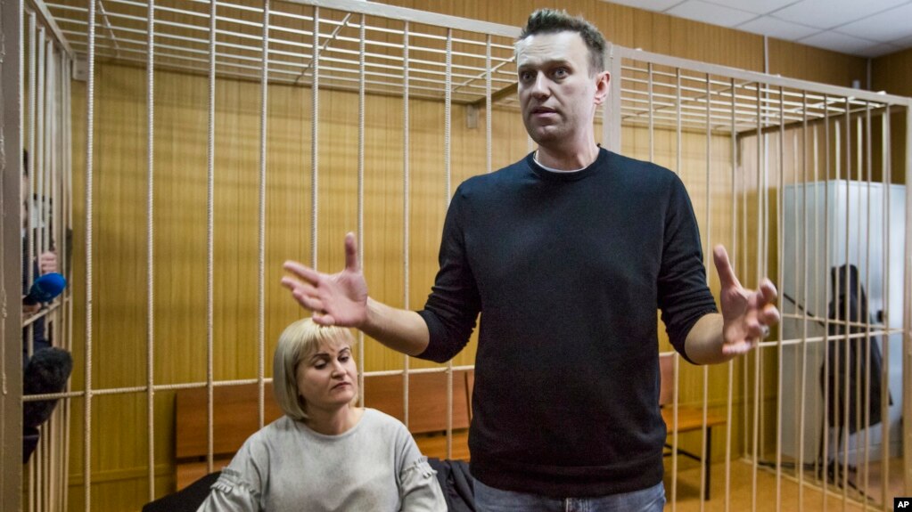 Russian opposition leader Alexei Navalny gestures while speaking, as his lawyer Olga Mikhailova listens, in court in Moscow, Russia, March 27, 2017. 