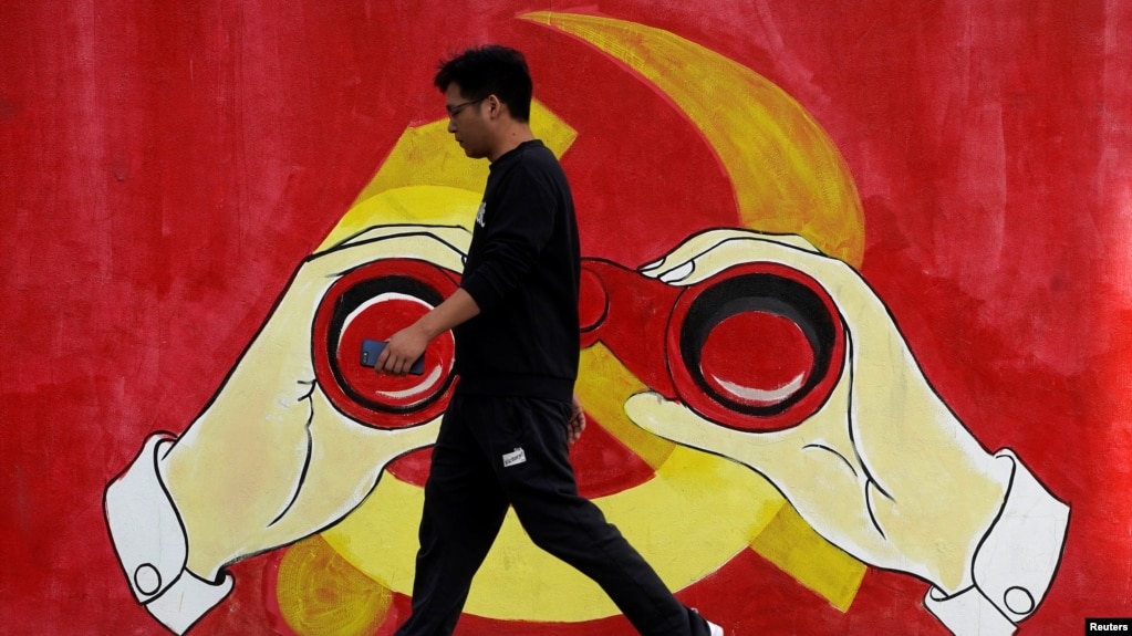 一名男子从上海街头中共党徽前走过。（2019年9月25日）
