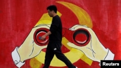 一名男子從上海街頭中共黨徽前走過。（2019年9月25日）