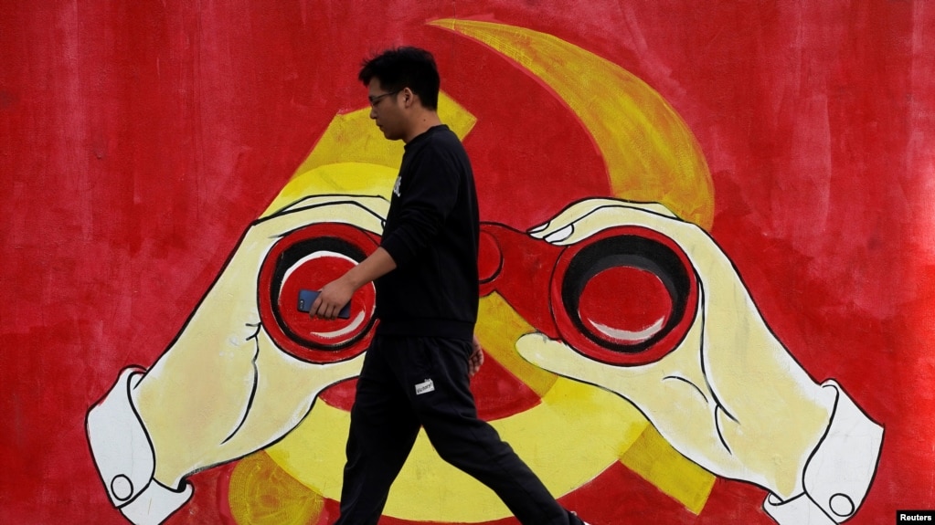 一名男子从上海街头中共党徽前走过。（2019年9月25日）