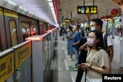 Orang-orang yang memakai masker saat menunggu metro, selama pandemi COVID-19, di Taipei, Taiwan, 11 Mei 2021. (REUTERS / Ann Wang)