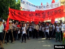 Villagers carry banners which read "Plead the central government to help Wukan" (in red) and "Wukan villagers don't believe Lin Zuluan took bribes" during a protest in Wukan, China's Guangdong province on June 22, 2016.