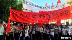 FILE - Villagers carry banners reading "Pleading with the central government to help Wukan" and "Wukan villagers don't believe Lin Zulian took bribes" during a protest in Wukan, in China's Guangdong province, on June 22, 2016. 