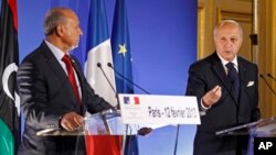 French Foreign Minister Laurent Fabius, right, addresses reporters during a joint press conference with his Libyan counterpart Mohamed Abdelaziz, left, at the end of a conference on Libya held at the foreign ministry in Paris, Feb. 12, 2013. 