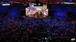 Delegates watch a video presentation during an abbreviated session of the Republican National Convention in Tampa, Florida, on Monday, Aug. 27, 2012.