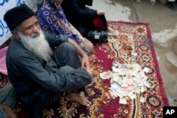 FILE - Pakistan's humanitarian leader Abdul Sattar Edhi collects donations at a roadside in Peshawar, Pakistan, Aug. 2, 2010.