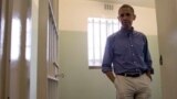 President Obama walks from Mandela's prison cell No. 5, on Robben Island.