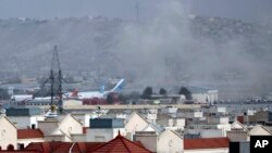 Asap mengepul dari ledakan mematikan di luar bandara di Kabul, Afghanistan, Kamis, 26 Agustus 2021. Dua pelaku bom bunuh diri dan pria bersenjata menargetkan kerumunan massa di dekat bandara Kabul. (Foto: AP)