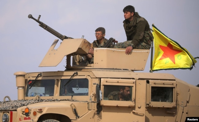Fighters from the Syrian Democratic Forces are seen on a military vehicle near Baghuz, Deir el-Zour province, Syria, March 6, 2019.