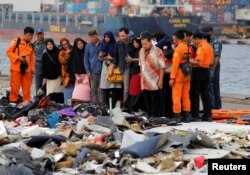 FILE - Families of passengers of Lion Air flight JT610 stand as they look at the belongings of the passengers at Tanjung Priok port in Jakarta, Indonesia, October 31, 2018.