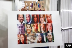 FILE - A poster showing all 14 victims is displayed during an interfaith memorial service at the Islamic Center of Redlands for the victims of the San Bernardino mass shooting, Dec. 6, 2015 in Loma Linda, California.