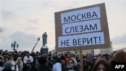 Opozicioni demonstranti na Puškinovom trgu u Moskvi sa transparentom na kome piše "Moskva suzama ne veruje"