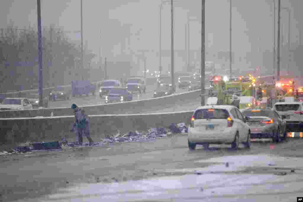 An Illinois State Trooper piles up debris on the side of the Kennedy Expressway after a 54 car pile-up early morning in Chicago.