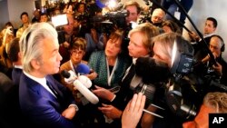 Dutch populist anti-Islam lawmaker Geert Wilders, left, speaks to journalists at a meeting of European Nationalists in Koblenz, Germany, Jan. 21, 2017.
