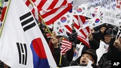 South Korean activists cheer as they wave flags of the United States and South Korea to celebrate the free trade agreement, or FTA, with the United States in 2012. 
