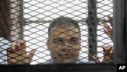 FILE - Mohammed Badr, a cameraman for Al-Jazeera Mubasher Misr, appears at a court in Cairo, Egypt. 