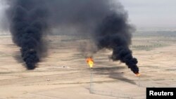 FILE - An aerial view of excess gas burning off at the al-Ahdab oil field in Wasit province, Iraq.