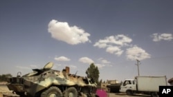 Armoured vehicles belonging to Muammar Gaddafi's troops, which were destroyed by an earlier air strike, are left near the village of Al-Qawalish July 18, 2011