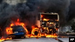 Vehicles burn in the street after attacks in the city of Fortaleza, northeastern Brazil, Jan. 3, 2019. 