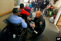 Mathew Meyer of the Nebraska Task Force 1 urban search and rescue team, right, talks with Korea war veteran Roman Wiggs, 87, as they evacuate an assisted living facility to a church as a precaution against potential flooding the city could see.