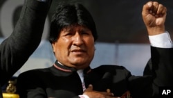 One day after a referendum on expanding presidential term limits, Bolivia's President Evo Morales sings his national anthem at a signing ceremony for the expansion of a road that connects the capital with the nearby city of El Alto, in La Paz, Bolivia, Mo