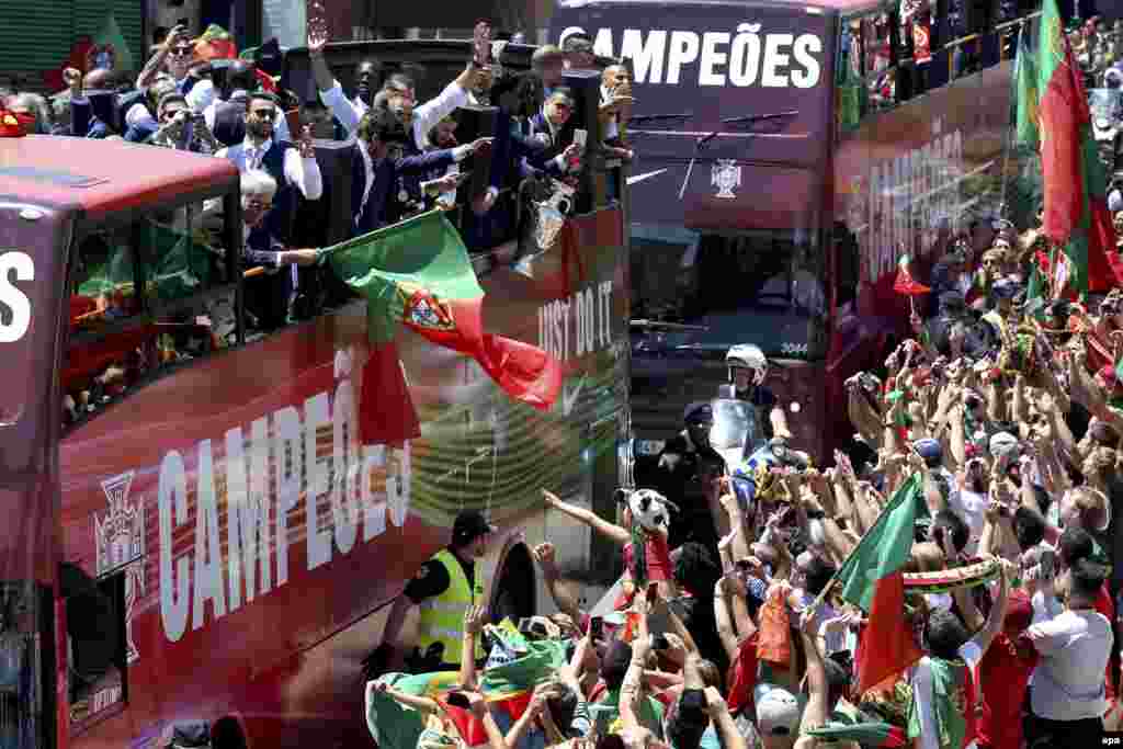 Les joueurs de l’équipe nationale portugaise montés sur un bus à toit ouvert, sont accueillis par une foule des supporters en liesse dans les rues de Lisbonne, Portugal, 11 juillet 2016. epa/ SETVEN GOVERNO