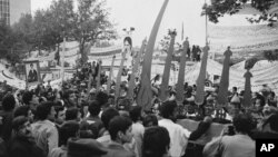 Simbolos religiosos acompañan la protesta frente a la embajada de EE.UU. en Teherán, donde estudiantes tomaron como rehenes a personal diplomático en 1979.