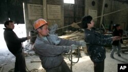 A migrant worker from Xi'an labors in a sculpture manufacturing company in one of Beijing's industrial neighborhoods Wednesday, March 30, 2005. Beijing announced the end of its rules limiting the life and work of immigrants Friday. While praising the loca