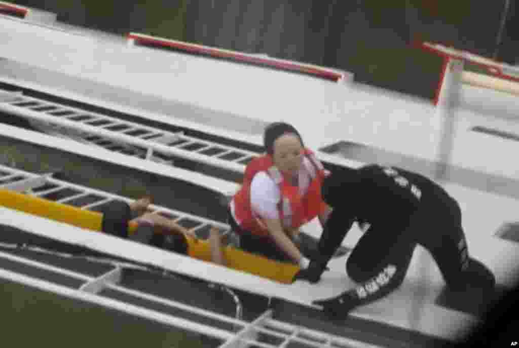 This image made from video from the South Korean Coast Guard shows a rescue worker helps people climb onto a side of a ferry sinking off South Korea's southern coast, April 16, 2014.