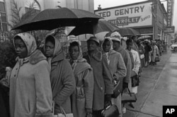 It rained all day but that did not dampen the spirits of blacks determined to register to vote. They stood in the rain trying to register in a priority book to take voter registration test in Selma, Alabama, Feb. 17, 1965.