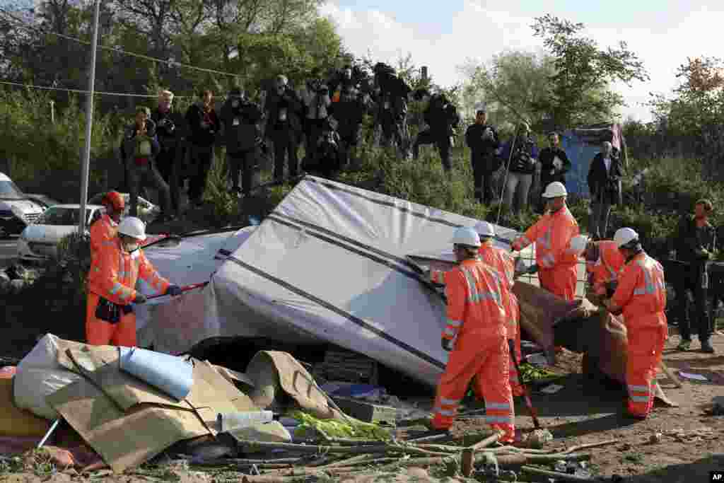 Crews start to demolish shelters in the makeshift migrant camp known as "the jungle" near Calais, northern France, Oct. 25, 2016. 
