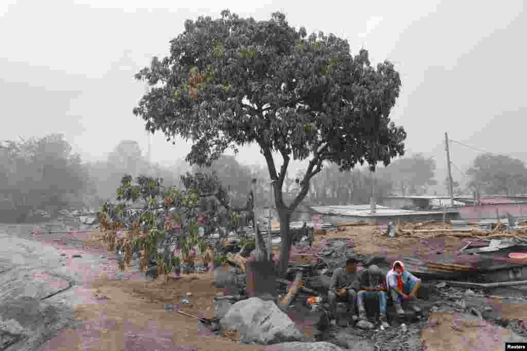 Residents pause during a search at an area affected by the eruption of Fuego volcano in San Miguel Los Lotes in Escuintla, Guatemala.